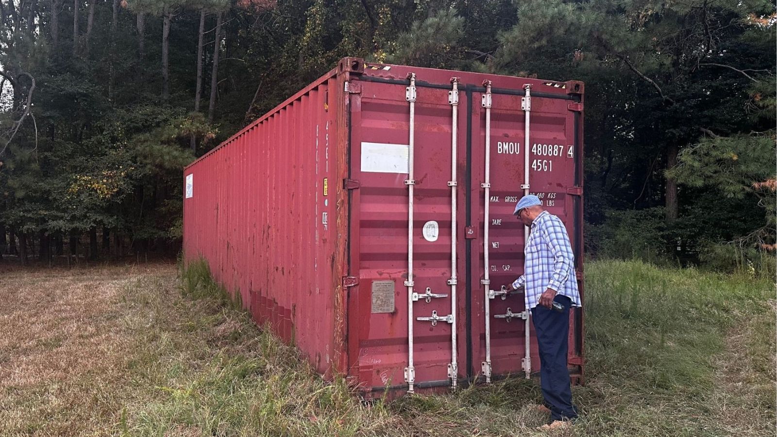 customer inspecting a used 40ft shipping container before paying at the truck